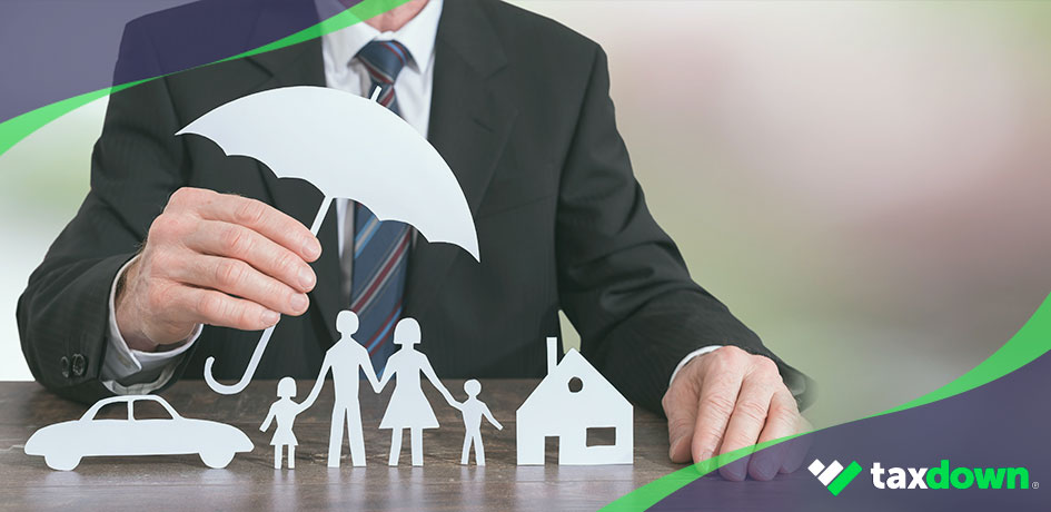 Persona con traje con un paraguas de papel protegiendo un coche, una familia y una casa representando un seguro que sería deducible
