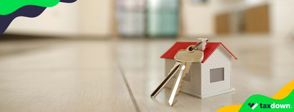 Imagen de una maqueta de una casa con unas llaves encima